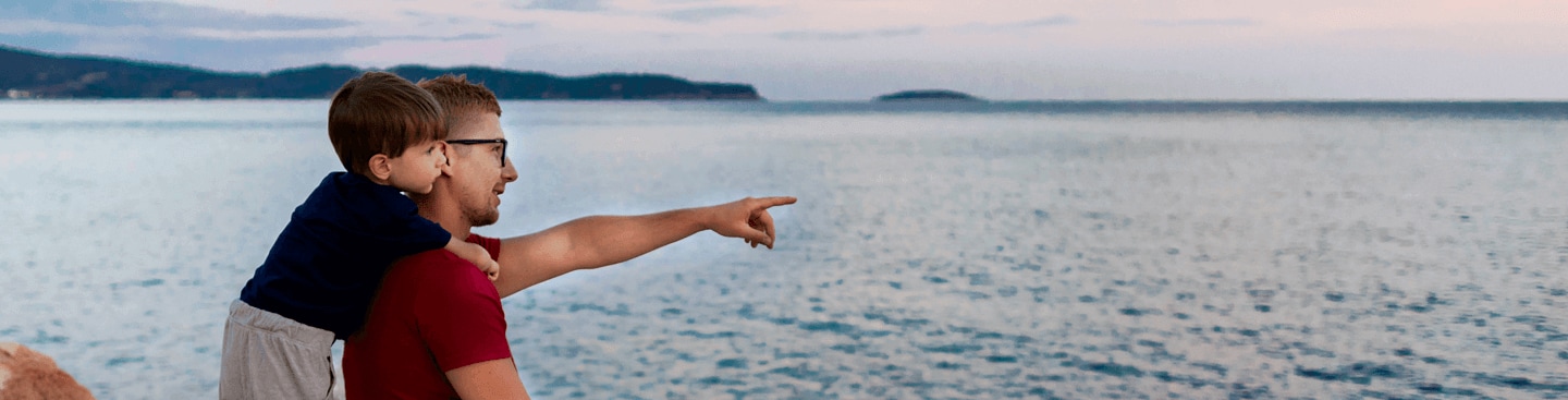 Father and son looking out across a body of water.