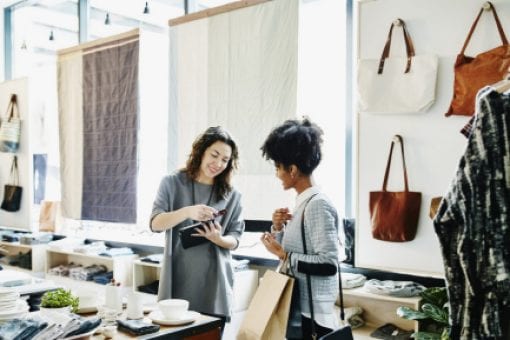 A store worker uses a card reader to swipe a customer’s credit card.