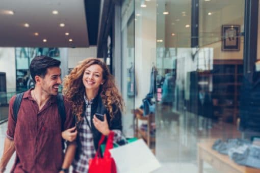 A happy couple shops at the mall.