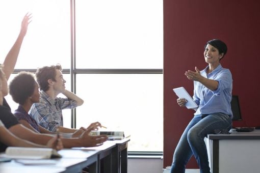 Female teacher calls on student raising his hand.