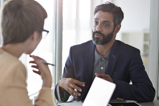 Coworkers speak together in an office.