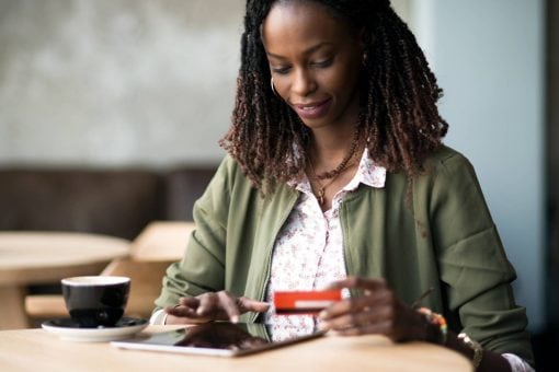 Woman uses tablet to check credit card rewards.