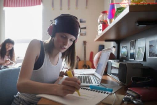 Group of young females doing homework in a dorm room.