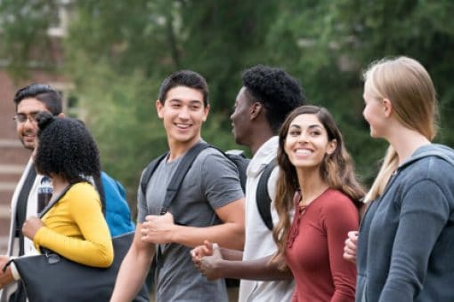 Group of diverse students walk and talk together.