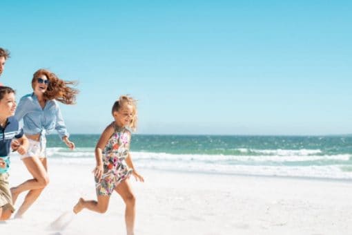 A cheerful family playing at the beach under the bright sun.