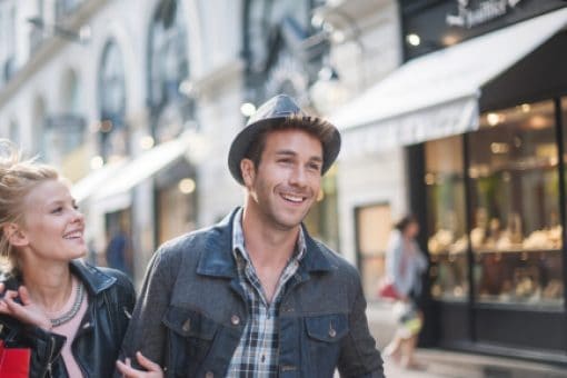 Happy couple walking and carrying bags after shopping together