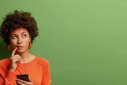 A man and a woman sit at a table with cups of coffee and some snacks while talking.