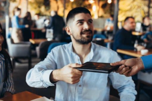 A man is handed the bill at a restaurant.
