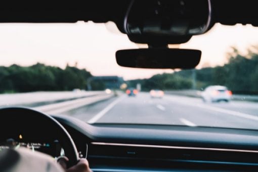 Person drives down the highway at dusk.