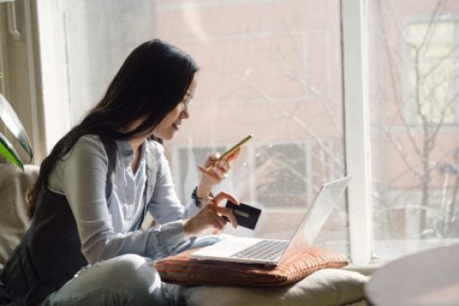 A woman reviews her credit report on her phone.