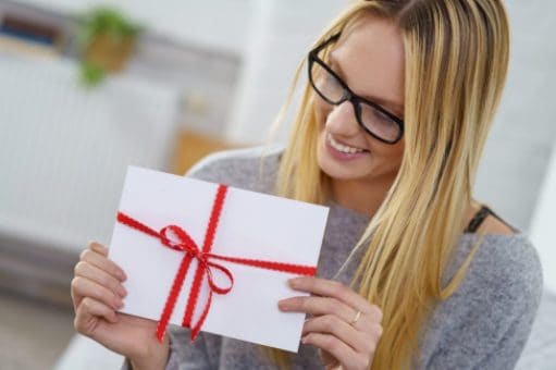Woman holding a gift card envelope tied with a bow