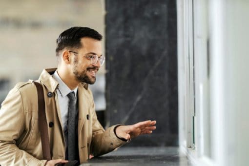 A man stands at a counter window ready to buy a money order.