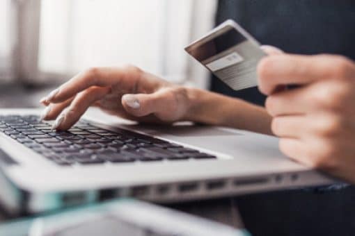 Person enters credit card information on laptop.