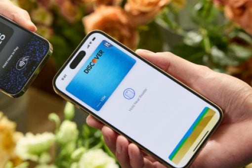 Two mobile phone held next to one another; one shows a transaction amount; the other shows a Discover card in a digital wallet.