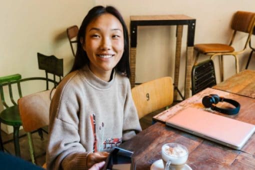 Cheerful woman paying for coffee with credit card