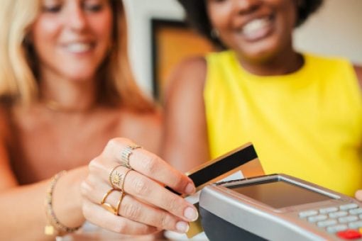 A woman uses her credit card at a point-of-sale terminal.