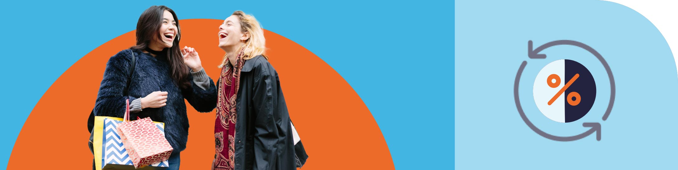 Two women laugh together as one of them holds shopping bags in her hand