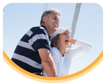 A smiling older couple on a boat on a sunny day.