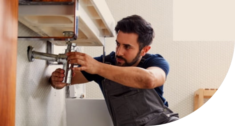 Image of man working on plumbing for a sink
