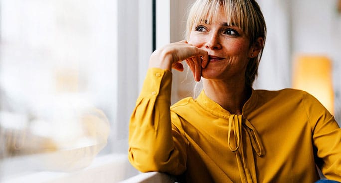 Image of a woman looking out a window smiling