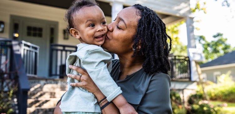 Image of person working on their finances with a calculator, and pen and paper