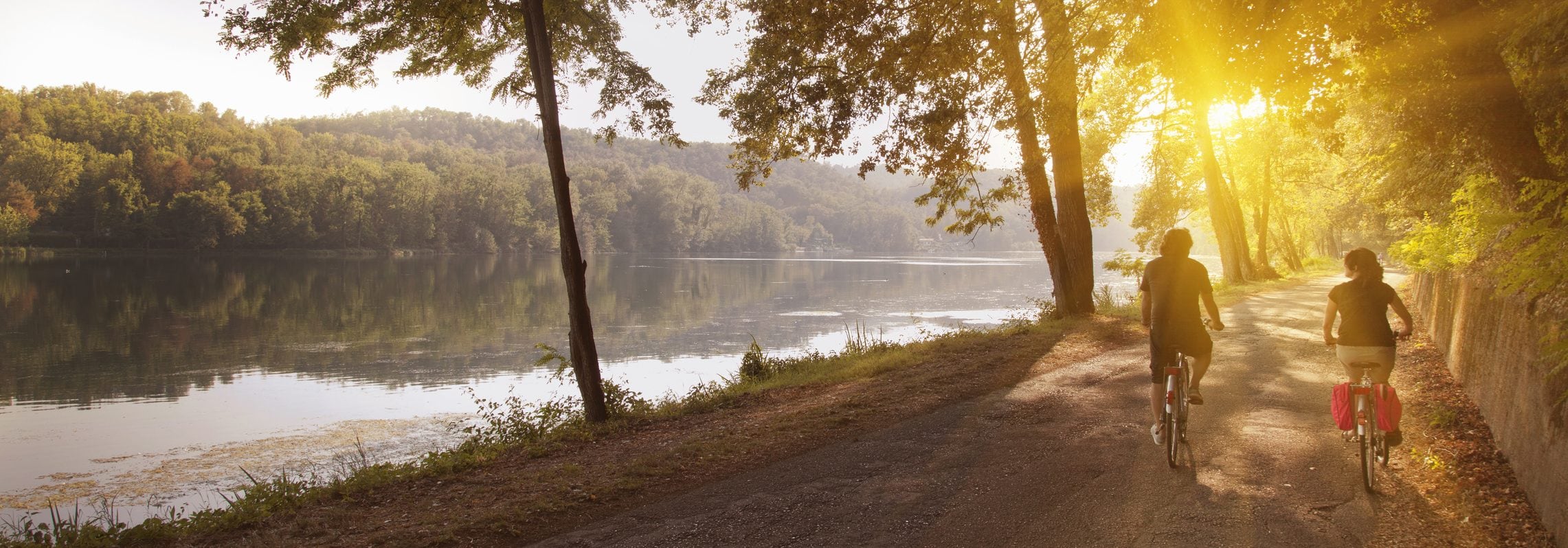 Couple riding bikes along the water.