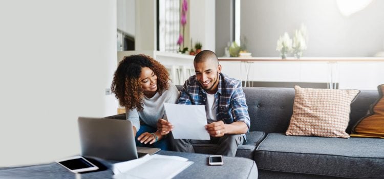 Wife and husband review their tax papers on the couch together.
