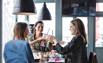 Three women toasting with various juice drinks.