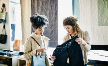 Two women look at a pair of pants.