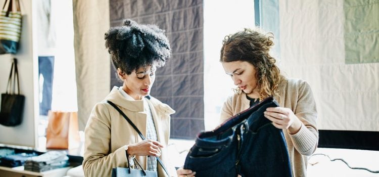 Two women look at a pair of pants.