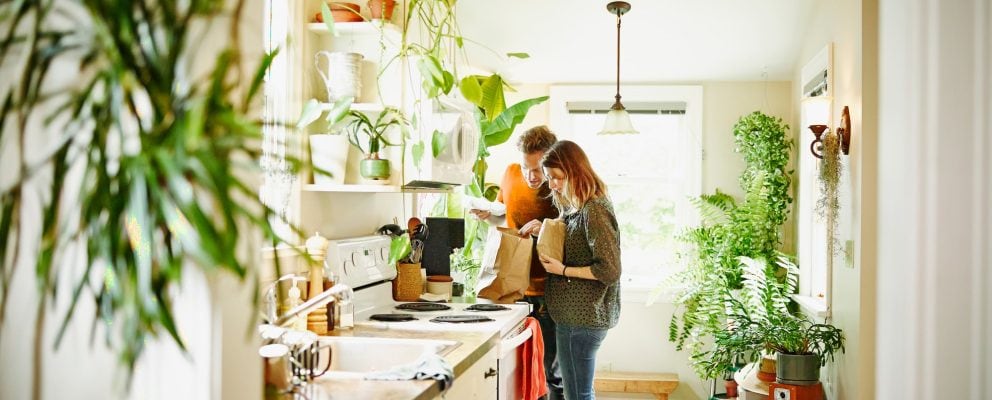 A couple looks through a grocery bag.