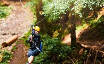 A woman rides a zip line.