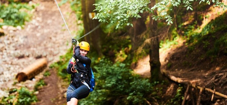 A woman rides a zip line.