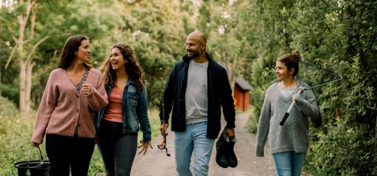A couple and their two daughters walk outside.