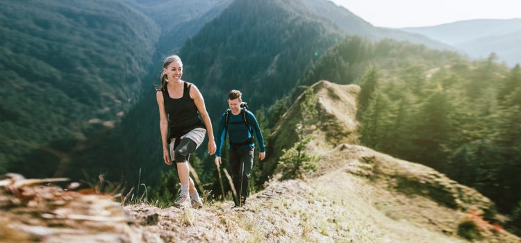A man and a woman hike on a mountain.