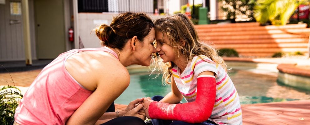 Mom and daughter smiling with their foreheads pressed together.