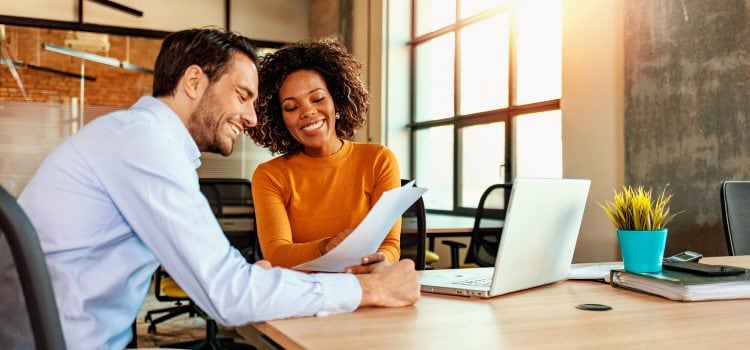Man and woman at office reviewing paperwork together.