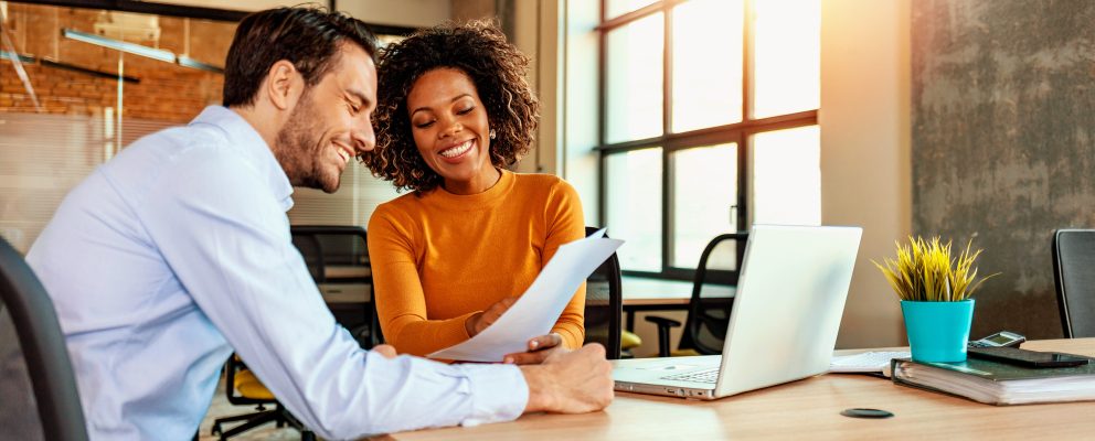 Man and woman at office reviewing paperwork together.