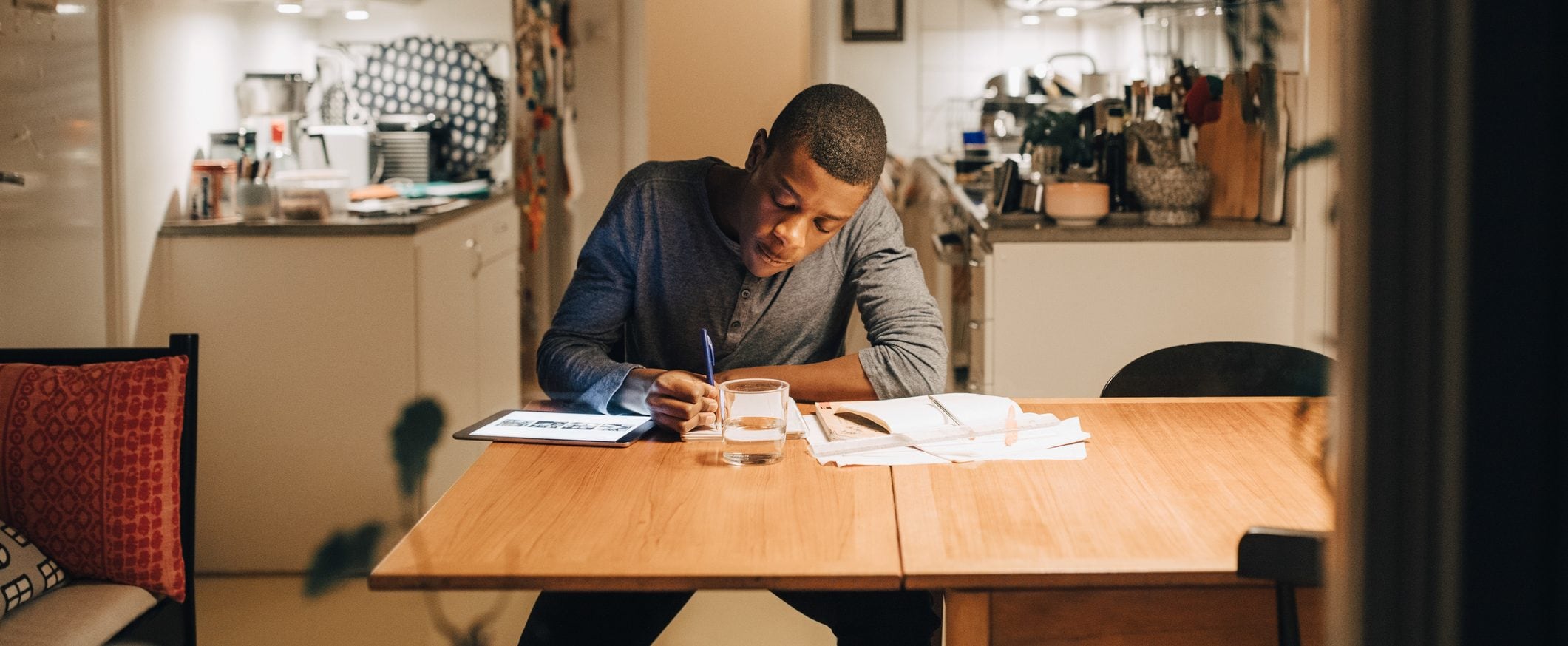 Man sits at a desk writing on paper.