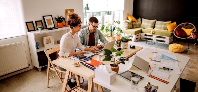 A couple looks at a laptop together.