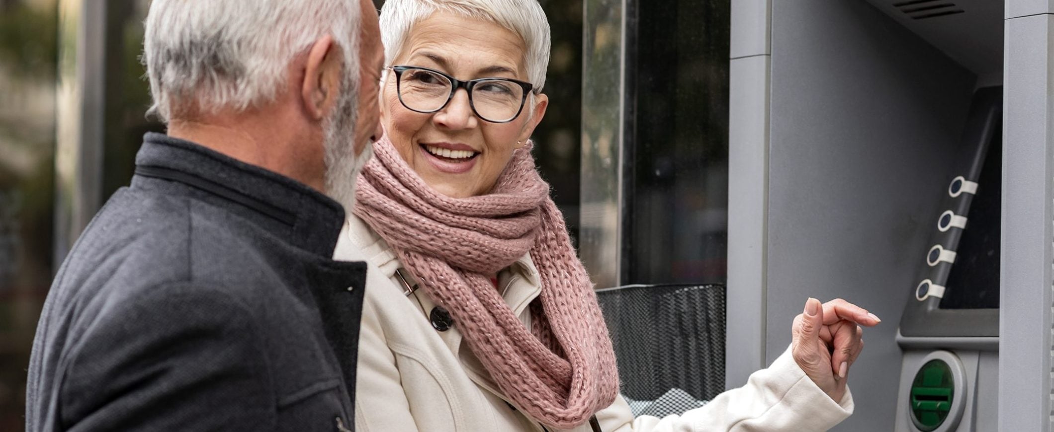 A couple stops to grab cash from an outdoor ATM.