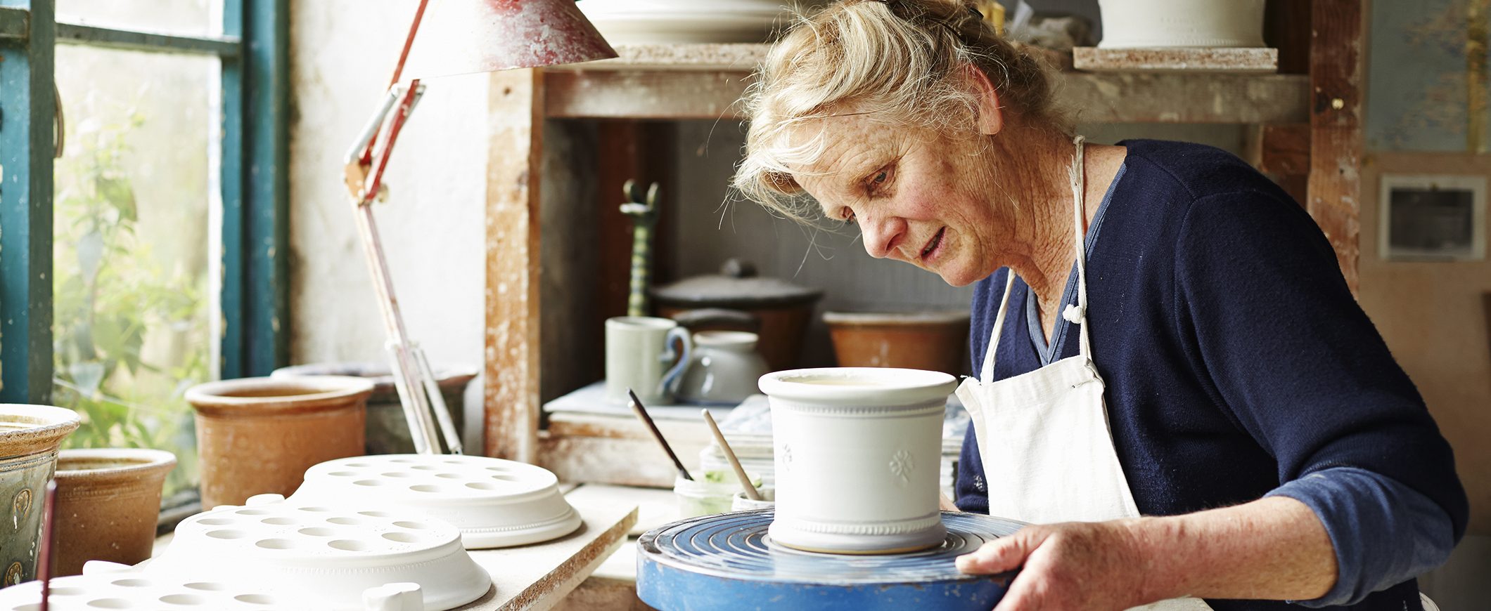 A small business owner creates pottery in her studio. 