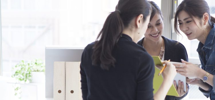 Three coworkers reviewing meeting notes in the office