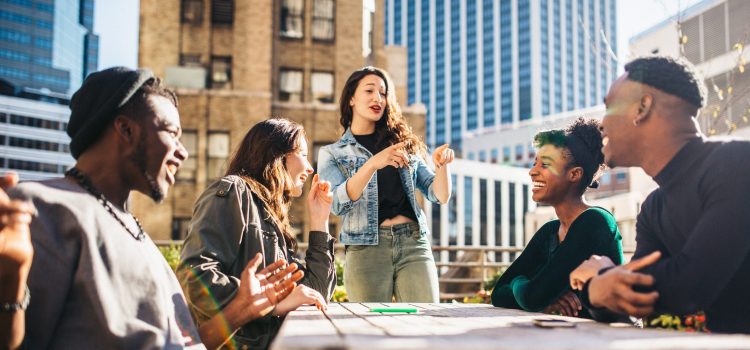 A weekend getaway with Group of five people talking outside on a rooftop.