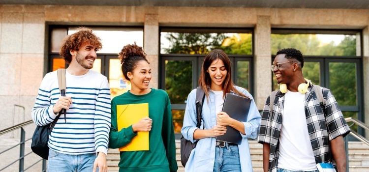 A group of 4 college students walk down stairs