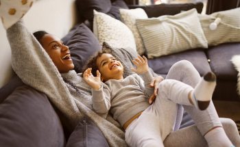 A mother and child play on a couch